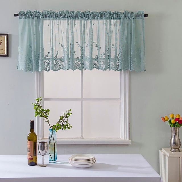 Meitianfacai Window Toppers Valances - Semi Sheer Valances Pleated Rod Pocket Linen Textured Fabric Window Dressing for Kitchen, Kids Room Short Drapes. The image shows a light blue lace valance with floral patterns, hung on a rod pocket above a window. The semi-sheer fabric allows natural light to filter through while providing privacy. The setting includes a dining table with a white tablecloth, a vase with green branches, a wine bottle, a glass, and stacked plates, creating a cozy and elegant atmosphere.