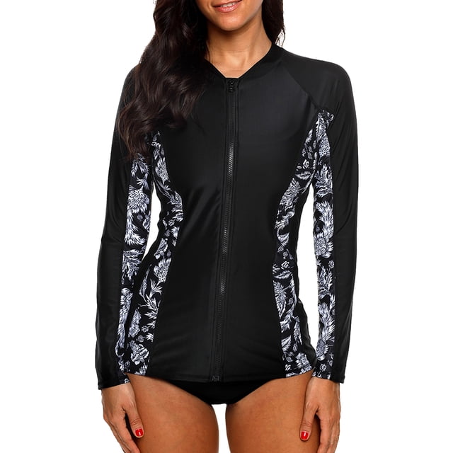 Charmo Womens Long Sleeve Rash Guard Top Zip Front Sun Protection Swim Shirt UPF 50+ in black with floral printed panels along the sides and sleeves. Features a front zipper closure, long sleeves, and a crew neck design. Made from 82% nylon and 18% spandex for elasticity and quick-dry comfort. Ideal for water activities like surfing, snorkeling, and paddleboarding. Provides UPF 50+ sun protection.