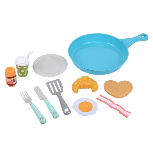 KC Breakfast Play Food Set includes a blue plastic frying pan, white plate, green polka-dot cup with straw, orange syrup bottle, light blue handled fork and knife, gray spatula, and pretend breakfast foods like a croissant, heart-shaped waffle, fried egg, and bacon strip, suitable for imaginative play for children aged 2 and up.
