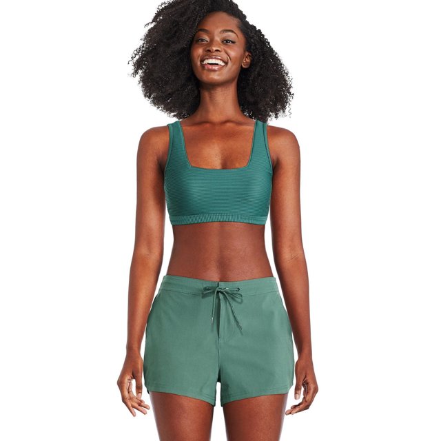 George Women's Square Neckline Bikini Top in teal green jacquard knit with thick straps and elasticized band, shown front-facing on a model wearing matching green swim shorts with a drawstring waist, set against a white background.