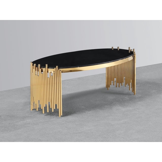 K-Living Venus Coffee Table with black glass top and gold polished stainless-steel base featuring an oval shape and vertical gold rods forming staggered legs, placed on grey carpeted floor against a plain light grey wall, ideal for modern living room settings.