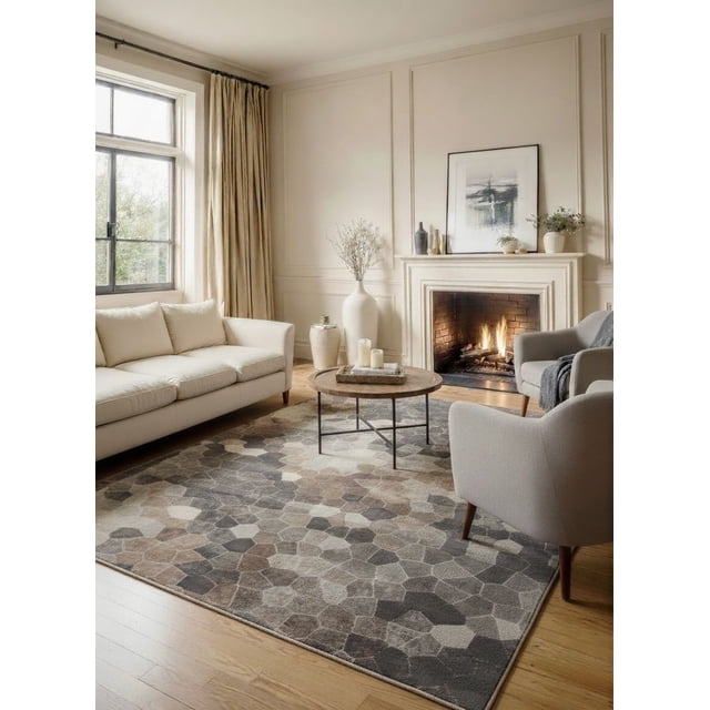 Rug Branch Havana Collection Tapis Traditionnel Usé en Fibres de Polypropylène à Coupe Basse et Résistant à l'Eau, Présenté dans un Salon avec sofa beige, Fauteuils Gris, table Basse Ronde en Bois et Foyer Lumineux. le Tapis Présente un Motif hexagonal en Mélange de Gris Neutres, de Bruns et de beige sur Plancher de Bois Franc, Idéal pour Compléter les styles de Décor Contemporains et Classiques.