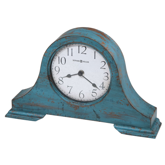 HOWARD MILLER TAMSON MANTEL CLOCK 635181 with a worn teal blue finish and rustic wooden design. Features aged Arabic numerals, black spade hands, and convex glass crystal over the aged dial. Powered by quartz movement, it requires one AA battery and includes a felt bottom to protect surfaces. Suitable as a decorative accent for mantels or tabletops.
