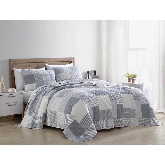 Chezmoi Collection Anderson 3-Piece Printed Patchwork Quilt Set in Queen size displayed on a bed in a bright, minimalist bedroom. The quilt features a stylish plaid checkered stripe design with various patterns, including glen check, windowpane, Shepard's check, and floral patches. Made of lightweight, pre-washed microfiber with a reversible plaid underside. Includes one quilt and two shams, ideal as a bedspread or coverlet for year-round comfort.