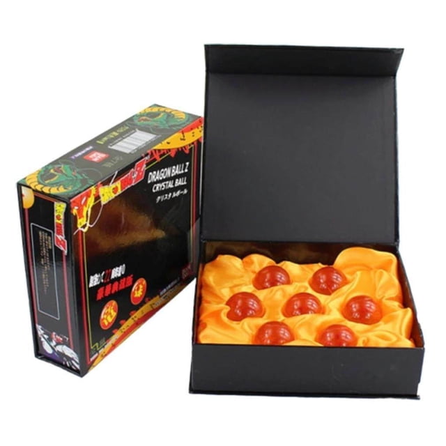 7PCS Dragon Balls Crystal Balls Crystal Glass Stars Balls Multifunctional Safety Anime Translucent Balls. The image shows a set of seven translucent resin balls, each featuring 1 to 7 stars, displayed in a black box lined with orange fabric. The packaging box, themed with anime graphics, is positioned beside the open display.