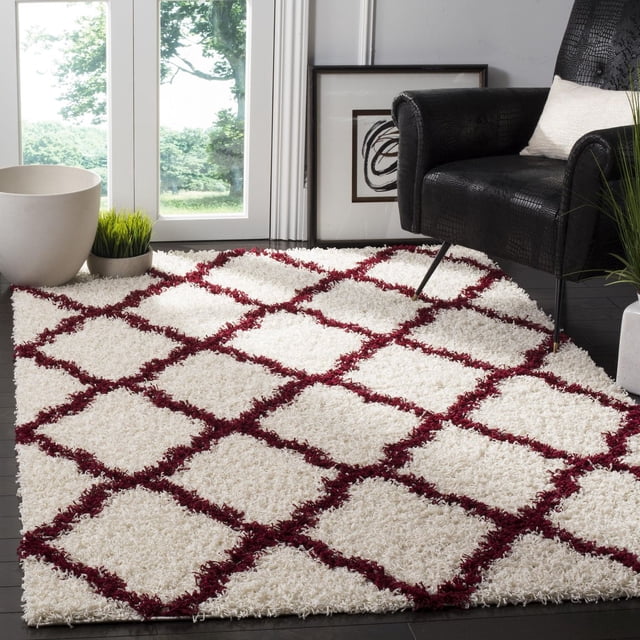 Safavieh Dallas Tapis Shag Géométrique Logan pour Aire avec texture Shag Peluche Ivoire et Motif de Carreaux Marocain Rouge, Ensemble sur Plancher de Bois Franc Foncé à Côté d'Un Fauteuil Texturé Noir, Près de Grandes Fenêtres avec Lumière Naturelle, Plantes Vertes et art Abstrait Encadré.