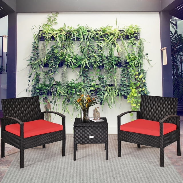 Costway Ensemble de Mobilier de Patio en Rotin 3 Pcs avec Deux sofas Simples en Rotin Noir Comprenant des Sièges Coussinés Rouges et une table Basse de Rangement Assortie. Conçu pour l'Extérieur, Cet Ensemble de conversation Résistant aux Intempéries Est Exposé sur un Patio avec un Mur vertical de Plantes Vertes en Arrière-Plan.