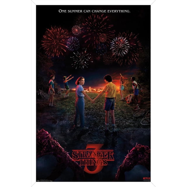 Netflix Stranger Things: Season 3 - Key Art Wall Poster showing six children on a rocky hill at night, two holding hands in the center, watching red and white fireworks over a lit small town, with the phrase 'One summer can change everything' above and the red 'Stranger Things 3' logo below.