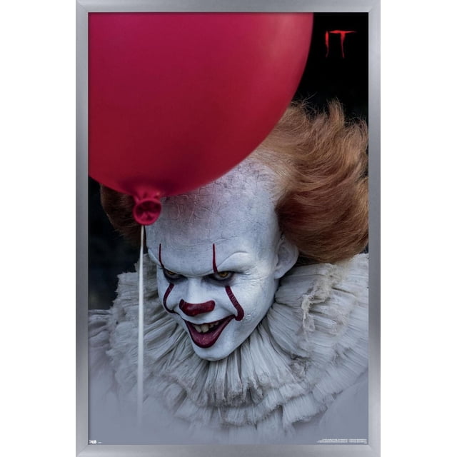 IT - Balloon Wall Poster, 14.725" x 22.375" featuring a close-up of a character with cracked white makeup, orange hair, and a layered white ruffled collar, partially obscured by a large red balloon, set against a dark background with the red 'IT' logo in the top right corner, ideal for horror-themed room decor or party decoration.