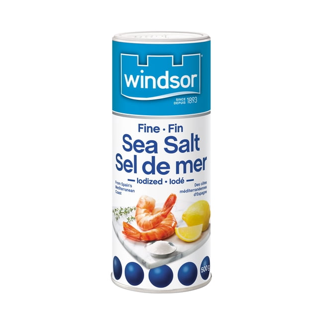 Windsor Contenant de Sel de Mer Fin Iodé 500 g avec Étiquette Bleue et Blanche Mettant en Vedette le logo Windsor, Texte Bilingue de Sel de Mer Fin, et une image de Crevette Cuite, Quartier de Citron et un Petit Bol de Sel de Mer Fin sur une surface Marbrée, Mettant en Valeur Son Origine Méditerranéenne Provenant de la Côte Espagnole et Idéal pour Assaisonner Fruits de Mer et Légumes.