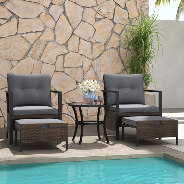Costway Ensemble de Mobilier d'Extérieur 5 Pcs Comprenant Deux Fauteuils en Rotin avec Coussins Gris, Deux ottomans Multifonctions et une table Basse Ronde à Dessus en Verre. l'Ensemble Est Fabriqué en Rotin PE Brun Mélangé et un Cadre Métallique Robuste, Conçu pour la Durabilité et le style. les ottomans Peuvent Être Utilisés comme Repose-Pieds, Sièges Ou tables d'Appoint et Se Rangent Facilement sous les Chaises. la table Basse a un Dessus en Verre Trempé Sécurisé avec des Ventouses. Idéal pour les patios, Jardins Ou au Bord de la Piscine, Cet Ensemble Offre une solution d'Assise Extérieure Confortable et