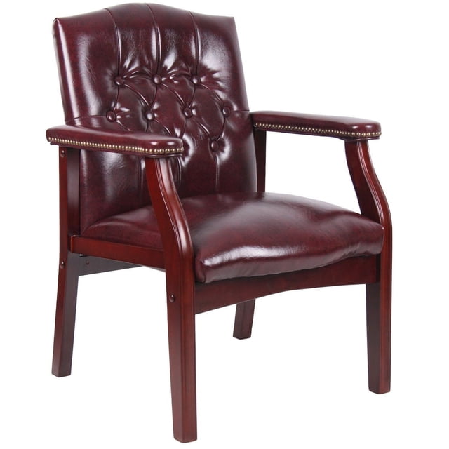 Nicer Furniture Interior Guest Chair upholstered in burgundy Oxblood vinyl with classic button tufted backrest, mahogany wood finish frame, padded armrests with antique brass nailhead trim, and thickly padded non-sag spring seat. Dimensions: 24.5-inch W x 27-inch D x 35.5-inch H (62.2 cm x 68.6 cm x 90.2 cm). Suitable for reception and conference rooms.