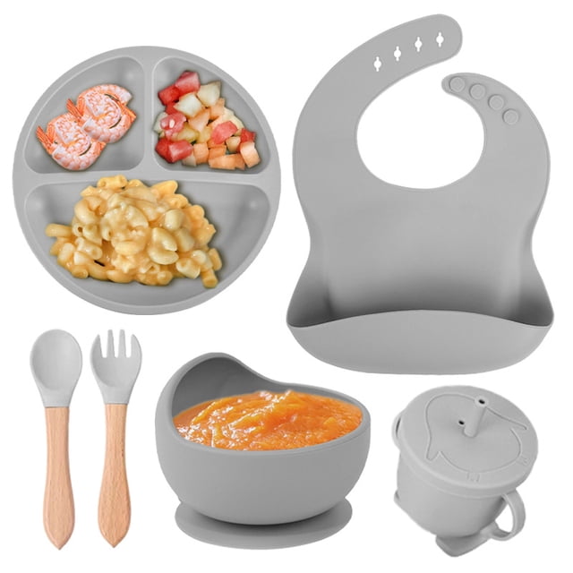 Children's complementary silicone plate baby complementary bowl smiley plate six-piece tableware set in grey. Includes a divided plate with three compartments, a suction bowl, a bib with a food-catching pocket, a sippy cup with a lid, and a spoon and fork with wooden handles. Made from durable, food-safe silicone, this set is lightweight and ideal for babies over 6 months old, designed for weaning and introducing solid foods. The cute design adds fun to mealtime, and the set is easy to carry for on-the-go use.