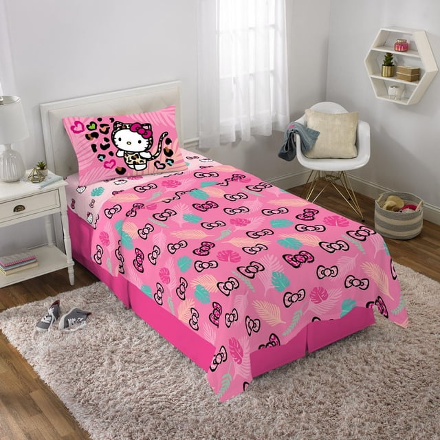 Hello Kitty « Jungle Sauvage » Ensemble de Draps Simple avec Drap-Housse en Microfibre Rose, Drap Plat et Taie d'Oreiller avec Imprimés Colorés de Feuilles et de Nœuds et Hello Kitty en Tenue à Imprimé Léopard. Montré sur un Lit Simple dans une Chambre d'Enfants Lumineuse avec des Murs Blancs, une Table de Nuit Blanche, une Chaise Blanche avec Coussin et un Tapis beige sur Plancher de Bois.