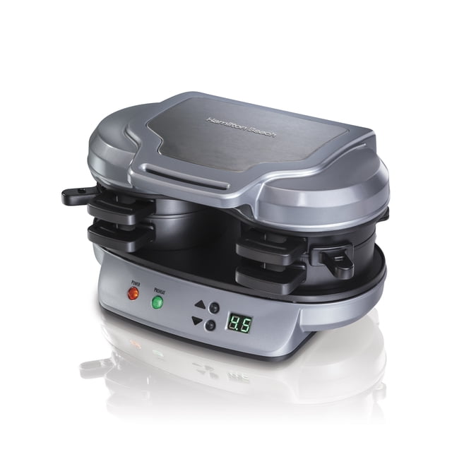 Hamilton Beach Dual Electric Breakfast Sandwich Maker with Timer in silver and black, showing a front 3/4 view with dual sandwich compartments, digital timer display, power and preheat indicator lights, designed for quick homemade breakfast sandwiches using English muffins, bagels, or biscuits.