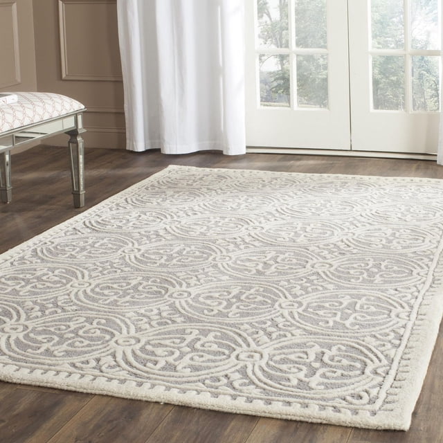 SAFAVIEH Cambridge Leslie Geometric Area Rug with hand-tufted wool texture and raised geometric circular patterns in light neutral tones, placed on hardwood flooring in a bright room, suitable for enhancing home or office decor with durable modern American style.