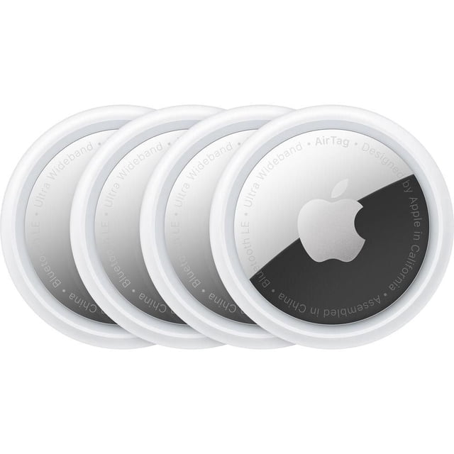 Apple AirTag set of four circular personal tracking devices with white plastic edges and a reflective silver Apple logo, featuring Bluetooth LE and Ultra Wideband technology for precise item tracking via the Find My app, also suitable for tracking luggage and backpacks.