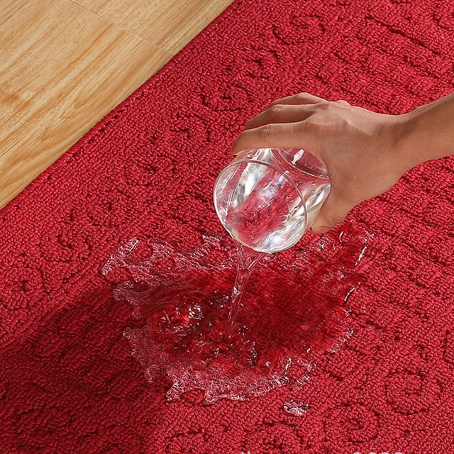 Half Circle Doormat Half Round Entryway Rug made of polyester fiber with a red textured surface. The image shows water being poured onto the mat, demonstrating its strong absorption properties. The mat features an anti-slip plastic point bottom for safety and is suitable for both indoor and outdoor use.