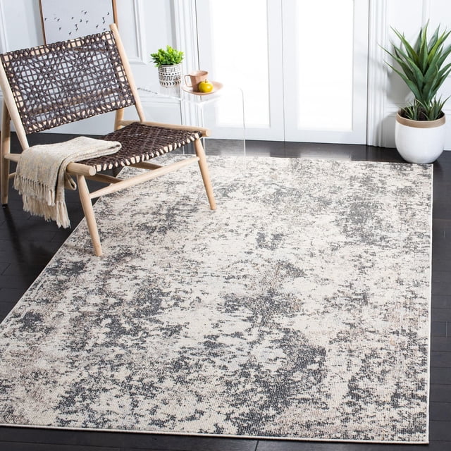 SAFAVIEH Madison Nita Vintage Floral Area Rug featuring a distressed beige and gray floral pattern, power-loomed for durability, placed on dark hardwood flooring. Styled with a woven wooden chair with a beige throw, a clear acrylic side table with decor, and a potted plant, suitable for enhancing transitional and contemporary home interiors.