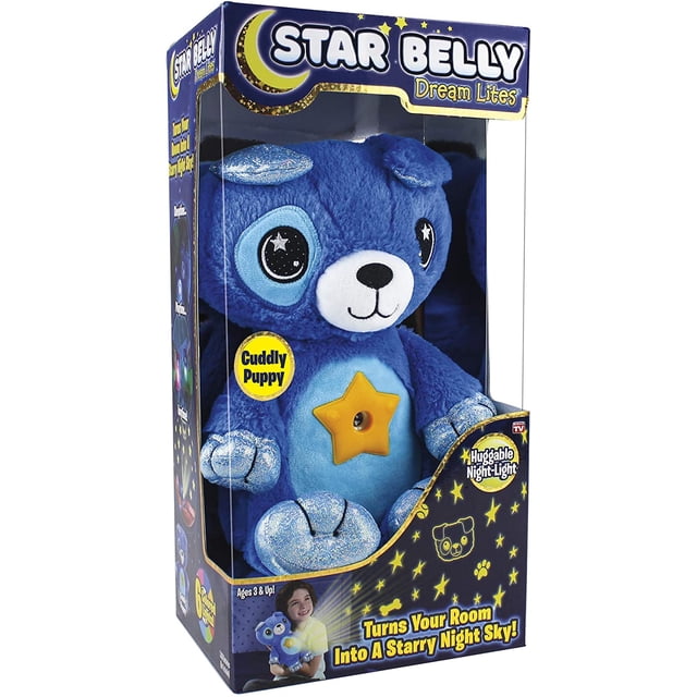 Star Belly Dream Lites Stuffed Animal Night Light Cuddly Blue Puppy in its packaging. This plush night light features a soft blue design with glittery accents on its ears and paws, a smiling face, and a glowing star-shaped button on its belly. It projects a starry sky in six colours, including blue, pink, and green, and is ideal as a bedtime companion for children aged 3 and up.