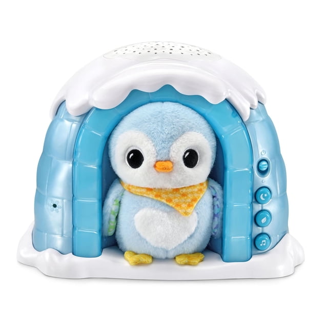 VTech Baby® Soothing Starlight Igloo™ - English Version showing a front-facing blue plastic igloo with white snow-like top and base, containing a removable plush blue penguin with large black eyes, orange beak, yellow feet, and a yellow patterned scarf. The igloo features three blue control buttons on the right side for power, night light, and sound, functioning as a baby sound machine and night light projector.