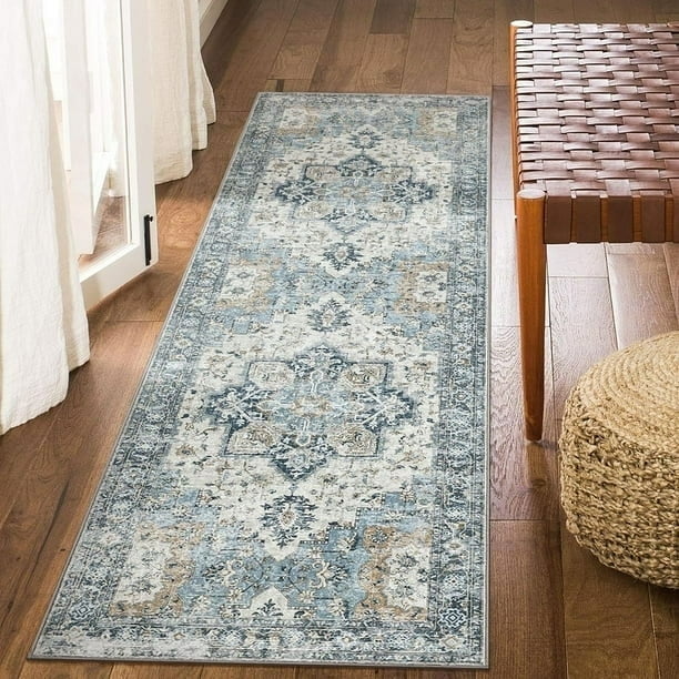 KUETH 2'x10' Machine Washable Rug, an ultra-thin non-slip runner rug with a vintage-inspired blue and gray abstract pattern. Designed for high-traffic areas like entryways and bedrooms, it features a low-profile woven polyester surface and a rubber backing for enhanced grip on hardwood or tile floors. Shown in a hallway setting with natural light and wooden flooring.