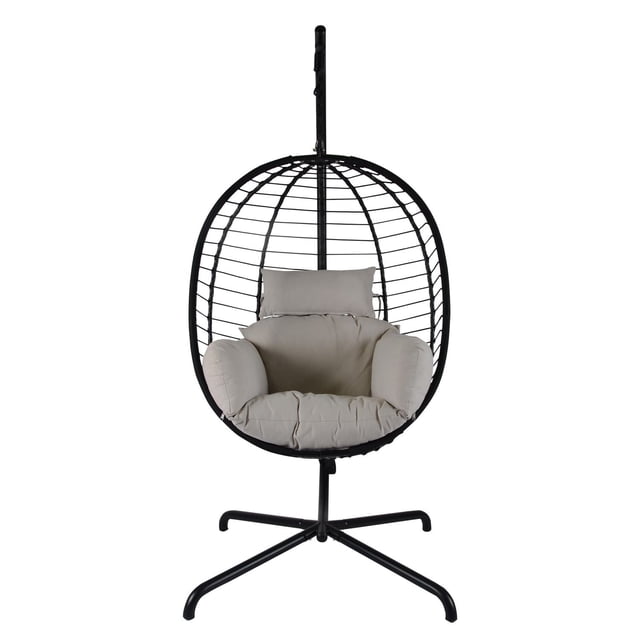 Ägg Hanging All-Weather Chair with a black electrostatic coated steel frame and hand-woven all-weather wicker forming an egg-shaped hanging seat, featuring light beige water, stain, fade, and mildew resistant cushions, supported by a four-legged stand ideal for porch or patio use.