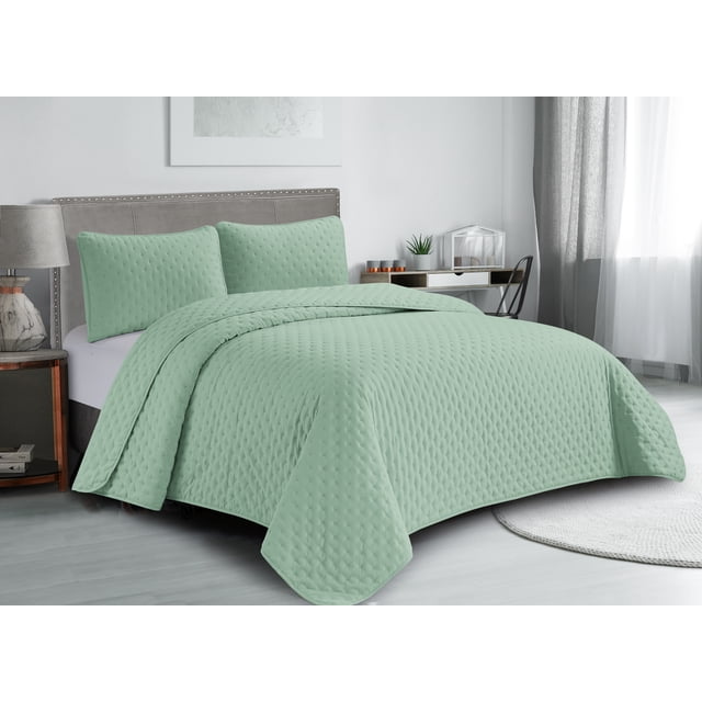 Swift Home Ultra Soft Pinsonic Quilt Set in sage green, lightweight hypoallergenic microfiber quilt with matching pillow shams on a grey upholstered bed in a modern bedroom, offering all-season comfort and easy care.