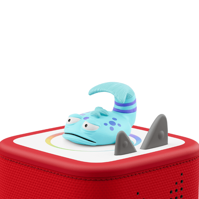 tonies The Pout-Pout Fish Audio Play Figurine featuring a multicolour blue fish with purple spots and stripes on its curled tail, placed on a red Toniebox speaker with white top and two grey fin-shaped buttons, part of educational electronics for kids offering screen-free entertainment and cognitive skill building.
