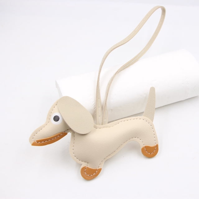 Leather Dachshund Keychain with Rope Handmade Sausage Dog Bag Charm featuring a beige leather dachshund shape with hand-sewn details and brown accents. Includes a long leather strap for versatile use as a keychain, dog accessory, bag charm, or handmade charm. Ideal for pet lovers and practical for preventing key loss.