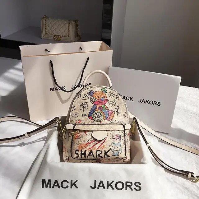 Ladies Fashion Backpack Mini Backpack Women PU Leather Shoulder Bag with a cute cartoon design, showcasing colorful animal illustrations and playful text. Made from durable PU leather, this compact and multi-functional bag is displayed on a white surface with branded packaging, ideal for casual outings or stylish accessorizing.