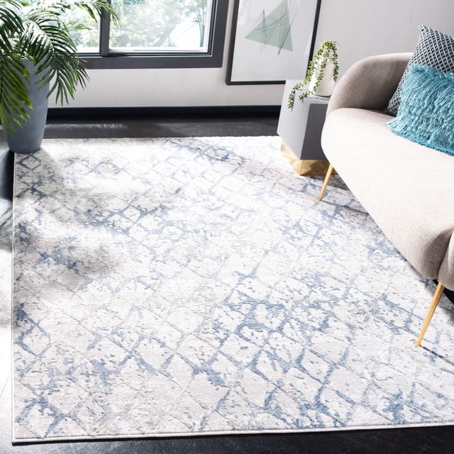 SAFAVIEH Amelia Roslyn Abstract Distressed Area Rug featuring a plush synthetic yarn texture with a light grey and blue abstract distressed pattern, placed in a modern living room under a beige sofa with blue accent pillows near a window and plants, suitable for enhancing contemporary home decor.