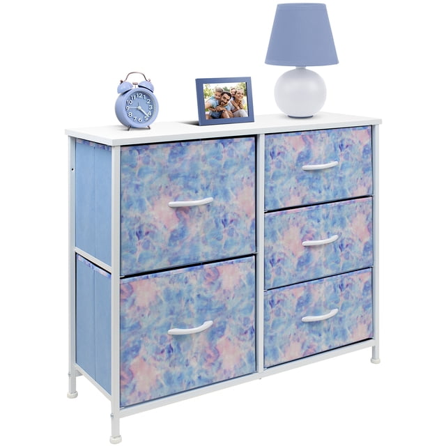 Sorbus 5-drawer chest dresser in tie-dye design, featuring a white MDF wood top and colorful fabric drawers. The dresser includes five spacious pull-out drawers supported by a sturdy steel frame. The tabletop displays a blue lamp, a framed photo, and a blue alarm clock. Perfect for organizing kids' clothes, toys, blankets, and household items. Suitable for use in kids' bedrooms, playrooms, or nurseries. Measures approximately 25” L x 11.87” W x 28.75” H.