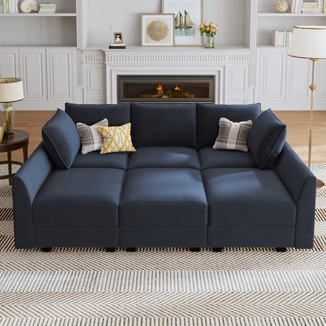 HONBAY Modular Sectional Sofa Bed Sleeper Couch with Storage, Inflatable, Velvet, Dark Blue. This sectional sofa is displayed in a cozy living room with a fireplace and decor. It features a modular design with six seats, hidden storage compartments, and pet-friendly velvet fabric in dark blue. Ideal for living room seating or as a sofa bed.