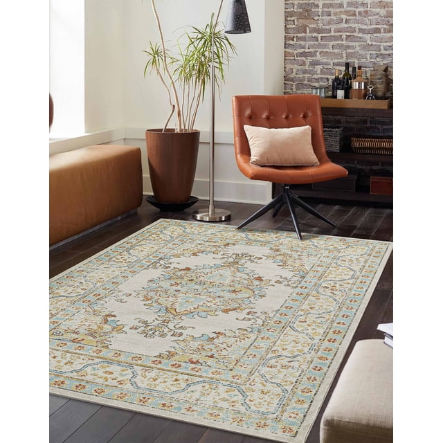 ECARPET Esme Traditional Area Rug for Living Room, Bedroom, Dining Room, Entrance, Hallway and More, featuring a rectangular machine-made rug with a traditional Turkish-inspired pattern in copper and blue tones on a light background, placed on dark hardwood flooring beside a brown leather swivel chair with a beige cushion, a tall potted plant in a wooden planter, and a modern metal floor lamp, ideal for busy family spaces due to its stain-resistant and durable design.