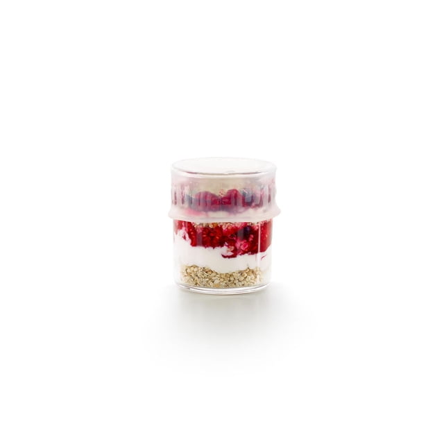 Lekue Couvercle Extensible flexible en silicone Réutilisable, 11,5 cm, Couvercle en silicone transparent Tendu sur un Petit Pot en Verre avec des Couches d'Avoine, de Yogourt et de compote de Petits Fruits Rouges, Montré Orienté vers l'Avant sur un Fond Blanc, Conçu pour l'Entreposage Hermétique des Aliments afin de Garder les Aliments Frais et Réduire le Pellicule Plastique à Usage Unique.