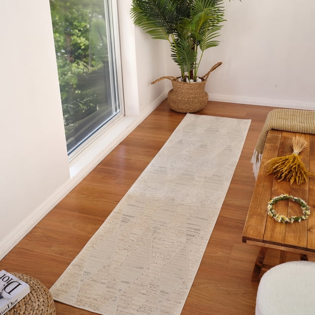 Modern cream beige abstract indoor area rug runner on wood floor next to window, styled with woven basket plant and rustic wooden table.