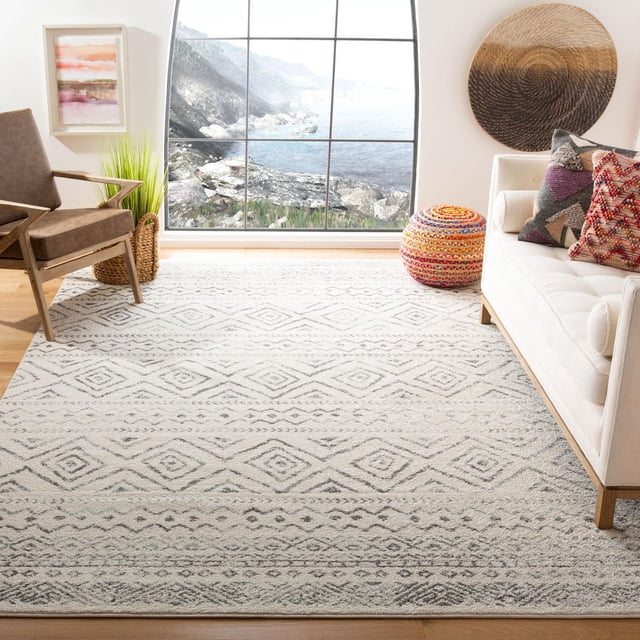 SAFAVIEH Tulum Merletta Tapis Géométrique Marocain en Tons Neutres Doux avec un Motif de Losanges Répétitif, sur Plancher de Bois Franc Clair dans un Salon Lumineux avec un sofa Blanc avec des Coussins boho-chic, un Fauteuil Brun, un Panier Tressé et une Grande Fenêtre Surplombant un Littoral Rocheux. Ce Tapis d'Accent durable Ajoute du Caractère Chaleureux et du Confort à Toute Pièce.