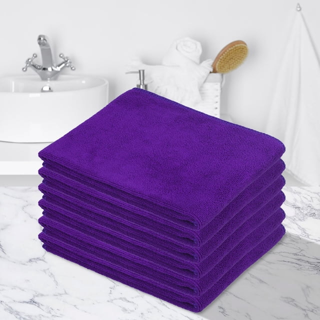 Fridja Super Soft Washcloths Towel Set 6 Pack in purple, featuring highly absorbent and soft material. Each towel measures 11.8'' x 27.5'' and is suitable for bathroom, hotel, spa, and kitchen use. The towels are displayed stacked neatly on a marble countertop in a bathroom setting with a sink and accessories in the background.