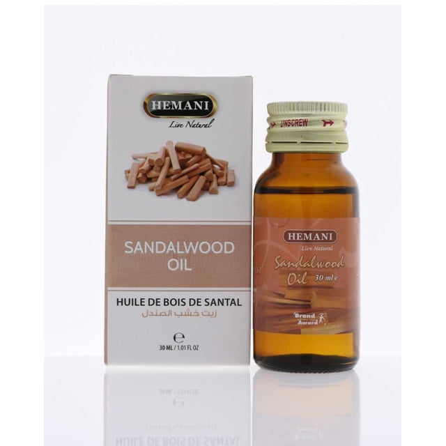Hemani Sandalwood Oil 30ml, featuring a 30ml amber glass bottle with a beige label and a matching beige screw cap, displayed alongside its packaging. The box showcases the Hemani logo, the product name in English, French, and Arabic, and an image of sandalwood sticks. This essential oil, derived from steam-distilled sandalwood, is known for its woody and earthy scent, commonly used in aromatherapy, incense, and perfumes.