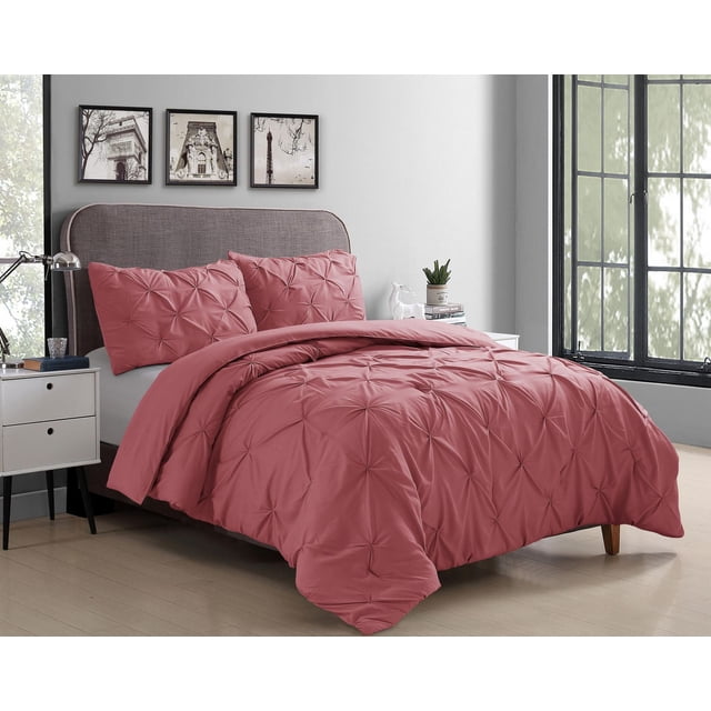Swift Home Pintuck Comforter Set in muted rose with textured pintuck pleats on comforter and pillow shams made from soft microfiber, displayed on a bed with a grey upholstered headboard in a bright bedroom with framed art and a white nightstand, suitable for all-season use.