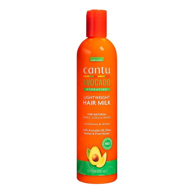 CANTU Avocado Hydrating Lightweight Hair Milk in a 12oz orange bottle with green and yellow accents. Designed for natural curls, coils, and waves, it features avocado oil, shea butter, and pure honey to moisturize and revive hair. The label highlights its paraben-free and silicone-free formula.