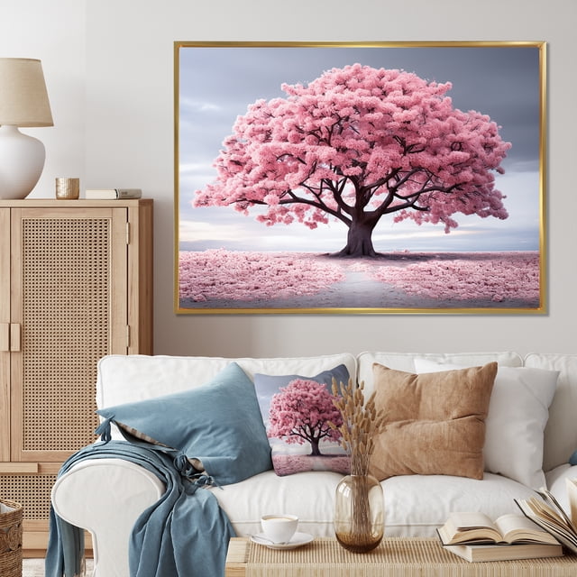 Designart Trees Oversized framed wall art decor featuring the Spring Awakening Pink Tree Serenade I design. The artwork showcases a vibrant pink tree in full bloom against a serene landscape, framed in a gold frame measuring 32x16 inches. The canvas is gallery-wrapped with the design continuing on the sides, stretched over a 1-inch wood stretcher. Displayed in a cozy living room setting with neutral-toned furniture and decor.