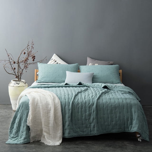 Kasentex Nostalgic Ensemble de Courtepointe à Pois Délavée à la Pierre Format Grand Lit, Exposée sur un Lit avec une Courtepointe Sarcelle Douce et des Taies d'Oreiller Assorties. la Courtepointe Présente un Motif Texturé à Pois et une Finition Lavée à la Pierre pour une Douceur Accrue. le Lit Est Stylé avec des Coussins Décoratifs et un Jeté Blanc, contre un Mur Gris Minimaliste et un vase avec des branches Séchées.
