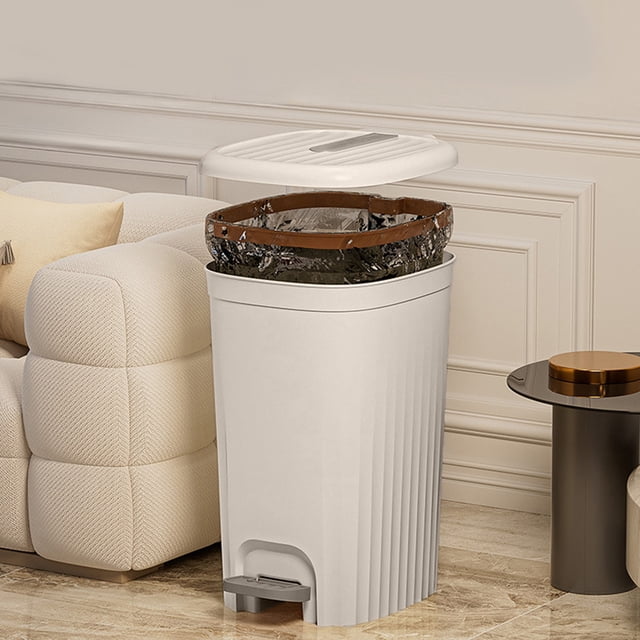 TIMIFIS Deodorizing Boxs Bathroom Trash Can with lid, shown in a grey plastic design with a foot pedal for hands-free operation. The trash can features a large capacity and a modern square shape, suitable for bathrooms, kitchens, or living rooms. The lid is open, revealing a plastic bag secured by a ring. Positioned in a stylish living room setting with a beige sofa and side table.