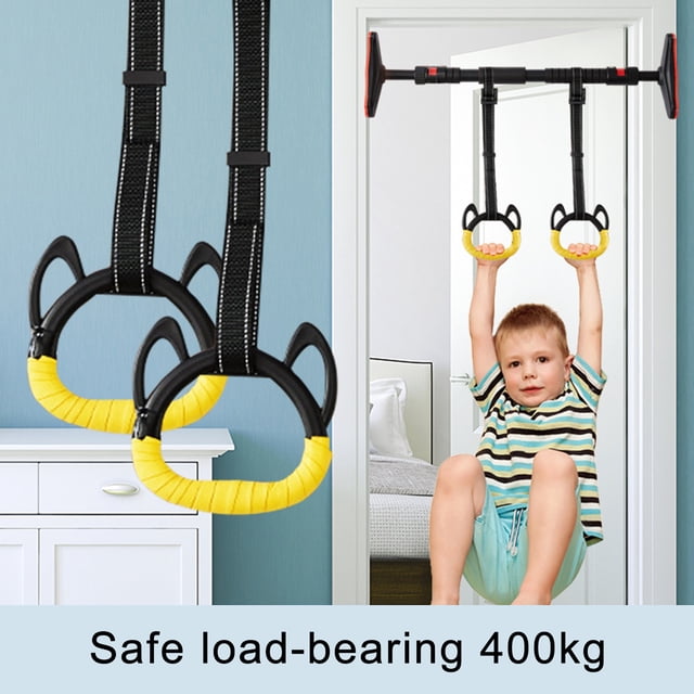 1 Set Gym Lifting Ring Sweat-Absorbed Non-slip Adjustable Strap Kids Gymnastic Gym Lifting Ring for Home. The image displays two black and yellow gymnastic rings with adjustable polyester cotton straps attached to a doorway pull-up bar. A child is actively using the rings for exercise, showcasing their load-bearing capacity and non-slip grip. Ideal for children's fitness, gymnastics, and spine-stretching exercises at home.
