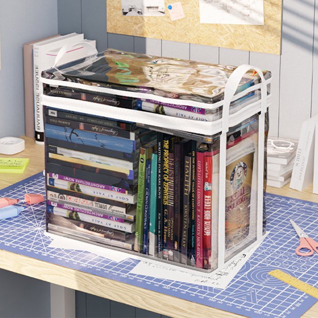 Student Book Storage Bag Transparent Storage Box Foldable Handheld Books School Supplies Organising Box. The image shows a clear PVC storage bag with a zippered top and white handles, filled with books of various sizes and colors. The transparent design allows easy visibility of the contents. The bag is placed on a desk with stationery and papers, showcasing its use for organizing school supplies or office items.