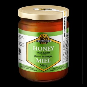 Wildflower 500g Honey by Dutchman's Gold in a glass jar with a gold lid. The label features green and white accents with text in English and French, highlighting it as unpasteurized honey made from golden rod, aster, and late summer wildflowers. Suitable for recipes or as a natural sweetener.