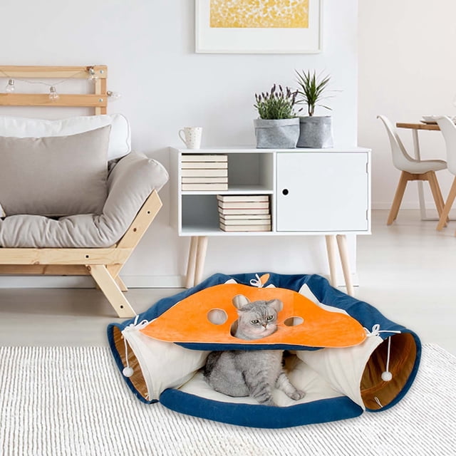 WIFKLSIIPG Tunnel pour Chat Tunnel pour Chat avec un design Pliable en Tissu orange et Bleu vibrant. Ce Jouet Interactif pour Chat Présente Plusieurs Ouvertures, des Jouets Suspendus et une Zone de Lit Douillette, Parfait pour Stimuler le Jeu et l'Exercice pour les Chats d'Intérieur. un Chat Gris Est Assis à l'Intérieur du Tunnel dans un Décor de Salon Moderne.