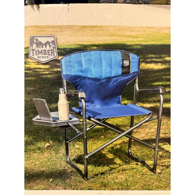 Timber Ridge D Frame Director’s Chair, featuring a lightweight aluminum frame with a durable blue polyester fabric seat. The chair includes a flip-down side table with a built-in cup holder and tablet holder, ergonomic plastic molded armrests, and reflective tape for nighttime visibility. Designed for outdoor use, it folds compactly and supports up to 136 kg (300 lb.).